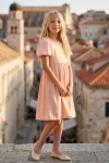 Rožinė proginė suknelė mergaitei Sia – visas siluetas senamiesčio bokšto fone